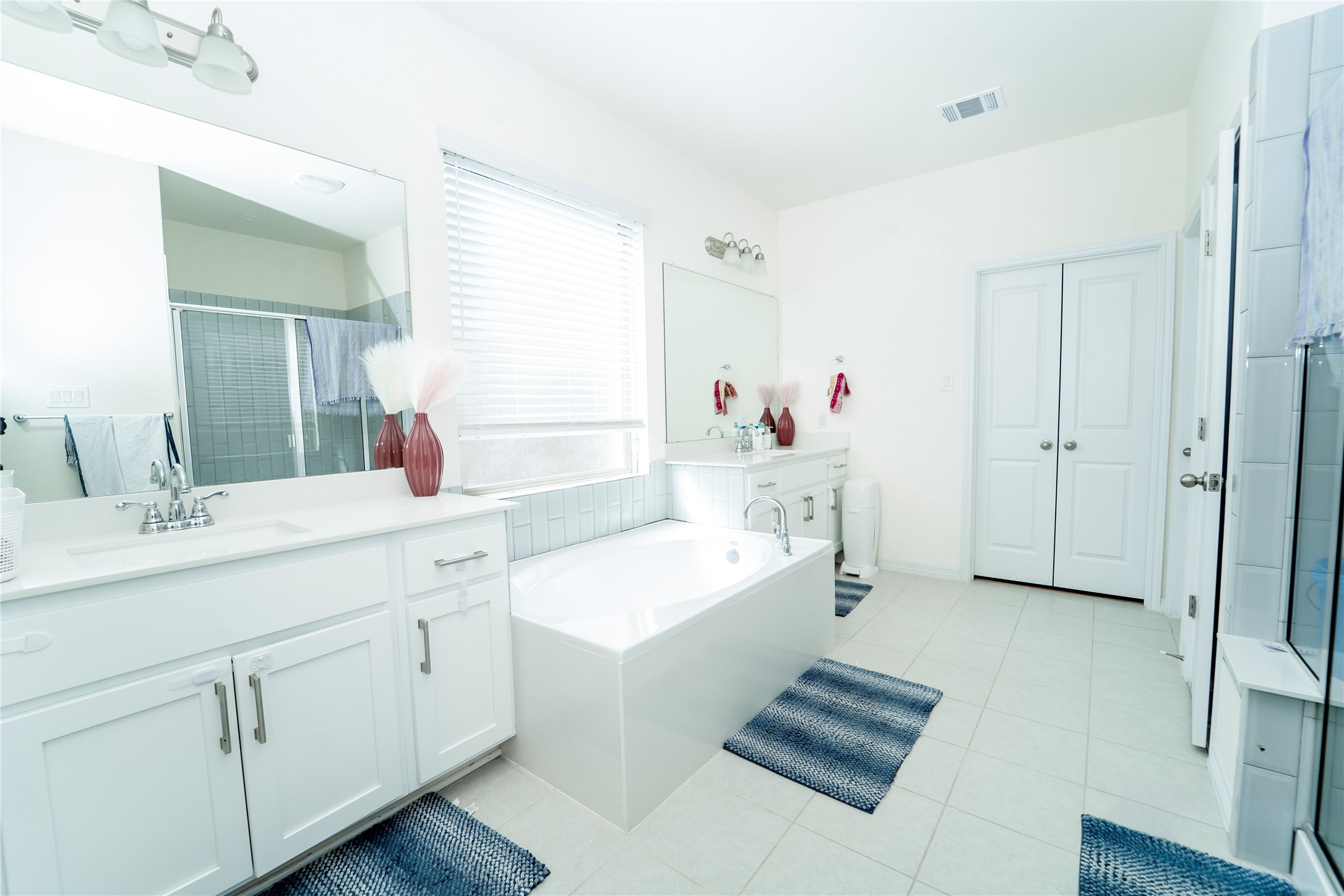 20813 Carries Ranch Road Pflugerville, TX 78660 - Photo 17 of 29 Bathroom featuring two vanities, a shower stall, a bath, and light tile patterned floors