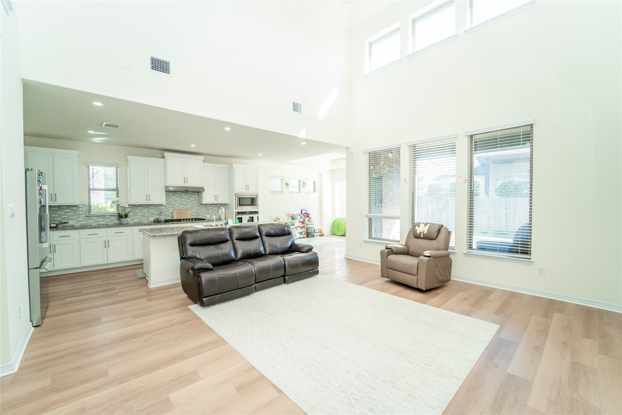 20813 Carries Ranch Road Pflugerville, TX 78660 - Photo 4 of 29 Living area featuring light wood finished floors, recessed lighting, and a high ceiling