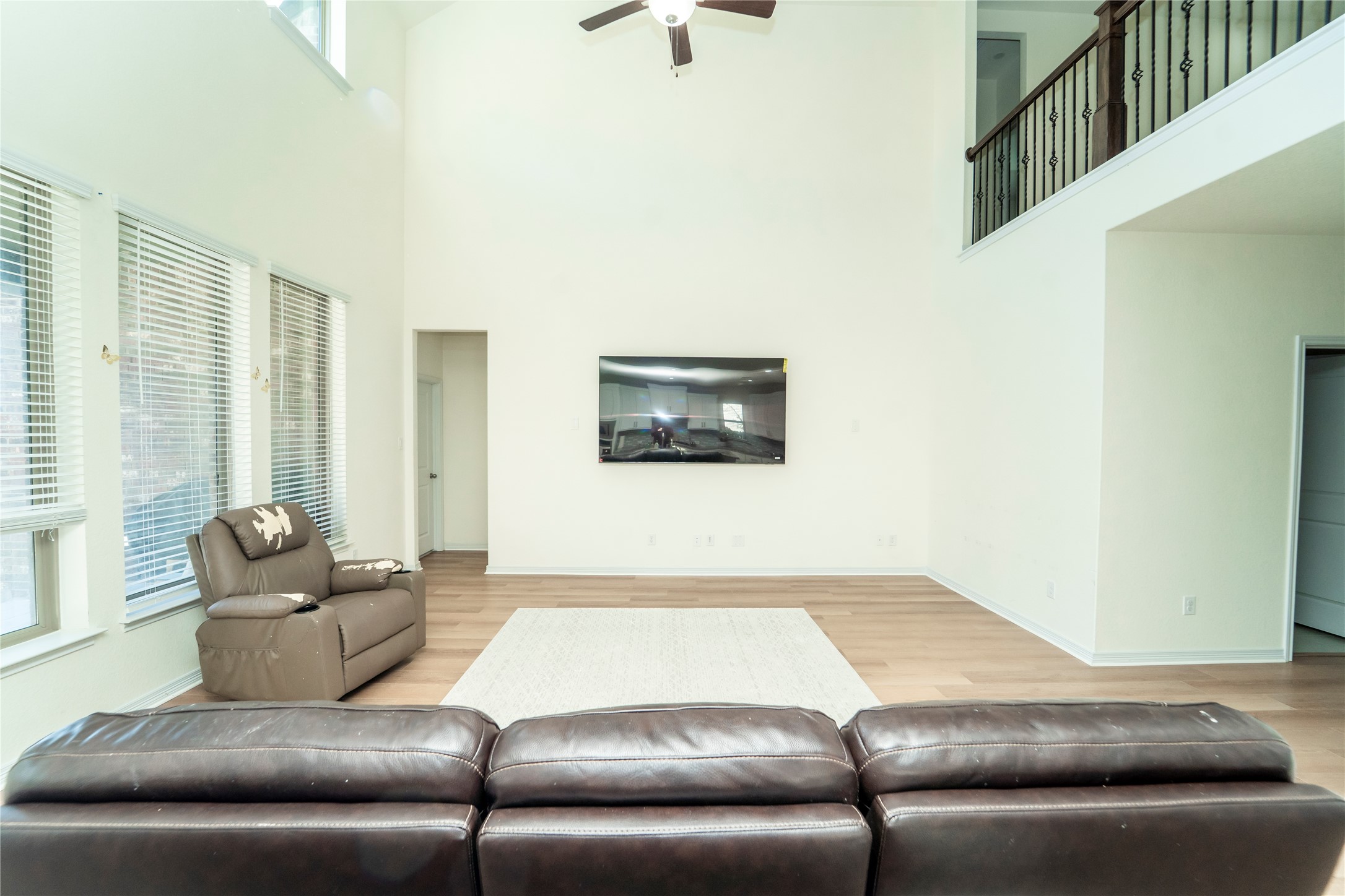 20813 Carries Ranch Road Pflugerville, TX 78660 - Photo 7 of 29 Living room featuring light wood-style floors, a ceiling fan, and a high ceiling