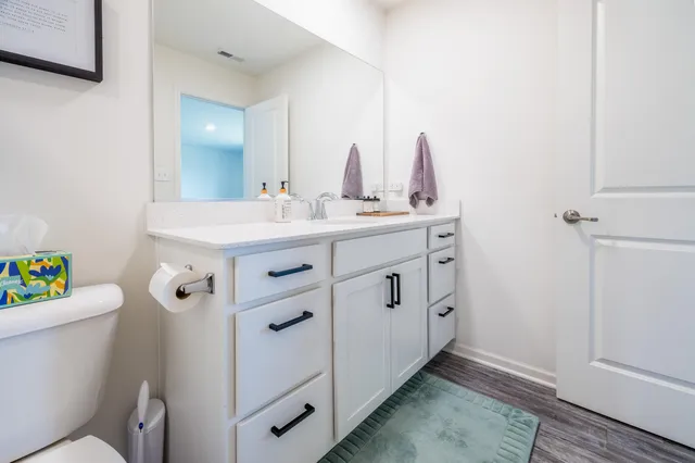 a bathroom with a sink a toilet a mirror and shower