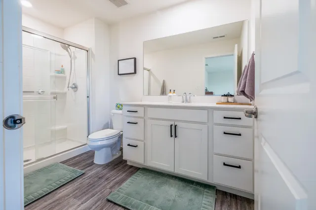 a spacious bathroom with a toilet sink and a mirror