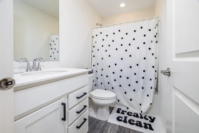 a bathroom with a sink a toilet a mirror and shower