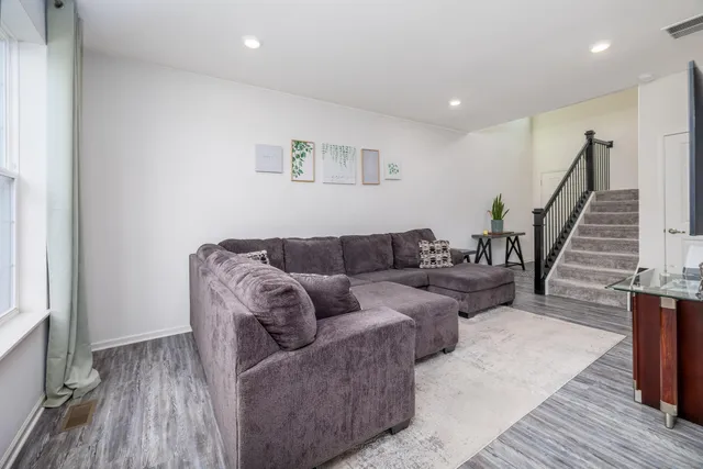 a living room with furniture and a wooden floor
