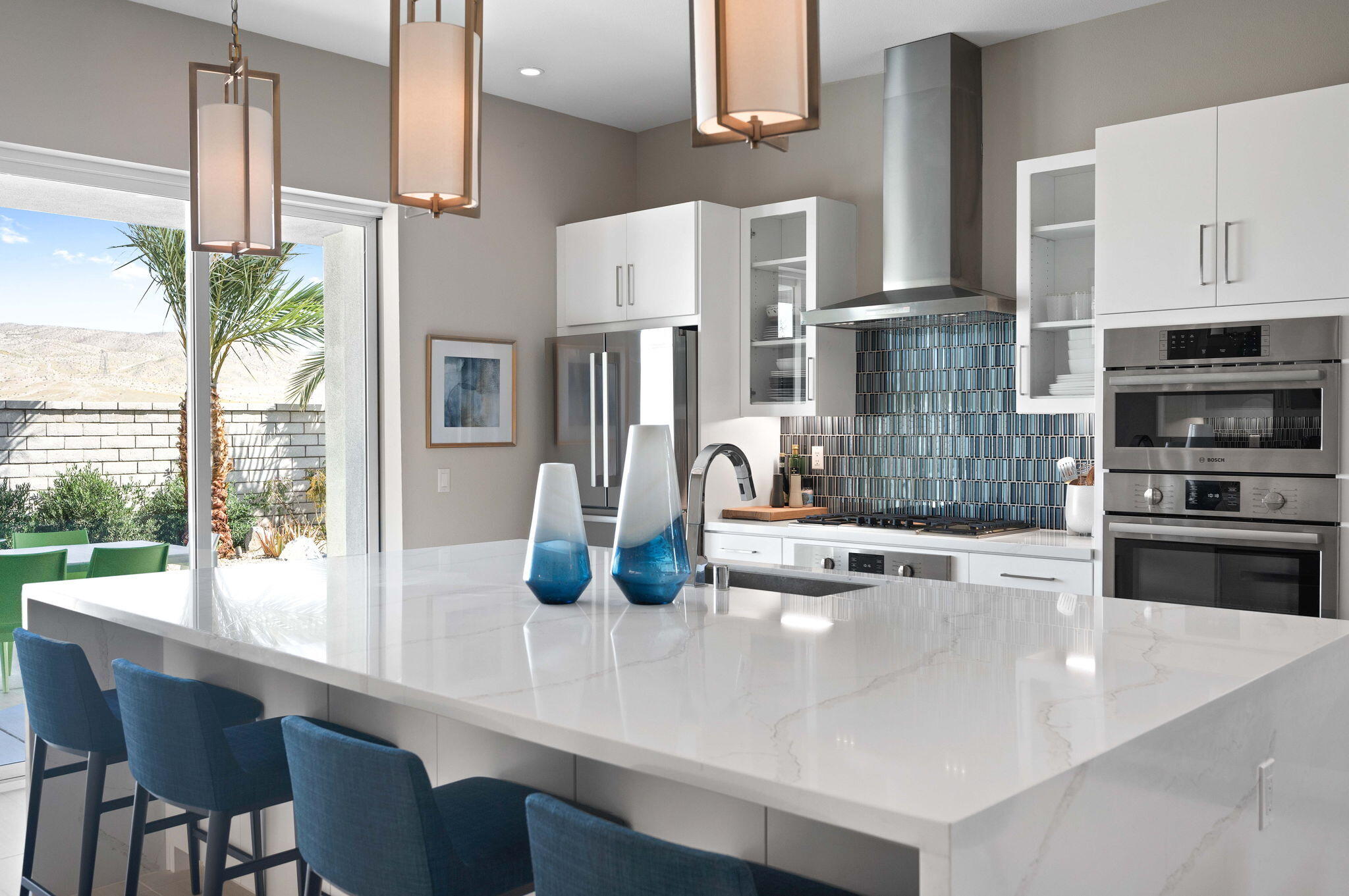 2 Iridium Way Rancho Mirage, CA 92270 - Photo 12 of 55 a kitchen with stainless steel appliances a table and chairs in it