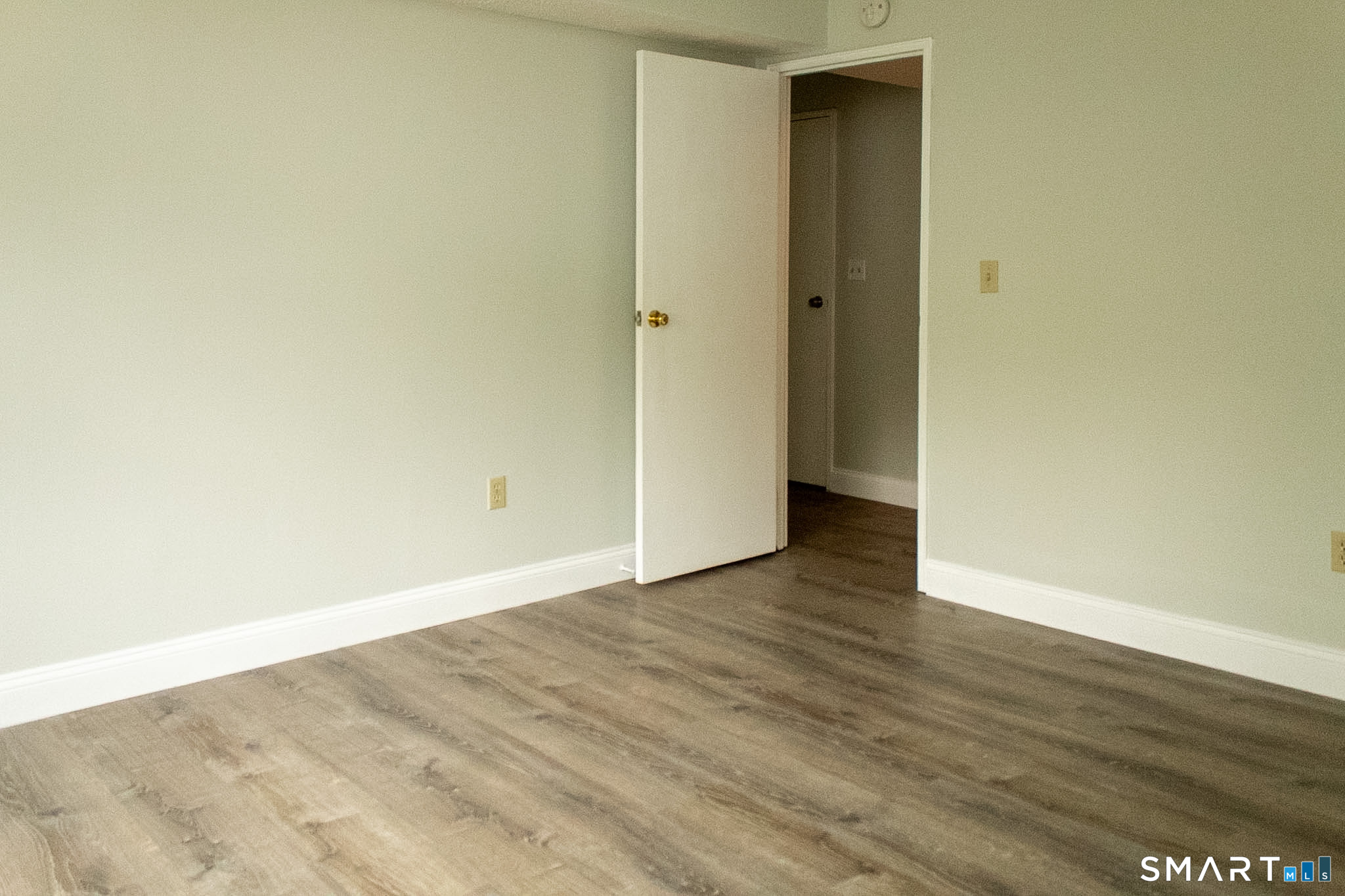 10 Georgetown Drive, Unit J Enfield, CT 06082 - Photo 9 of 15 a view of an empty room with wooden floor