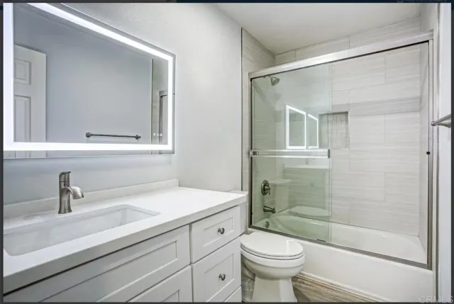 a bathroom with a sink a toilet and shower