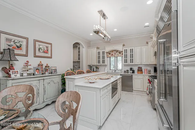 a kitchen with stainless steel appliances granite countertop a refrigerator a stove top oven a sink and cabinets