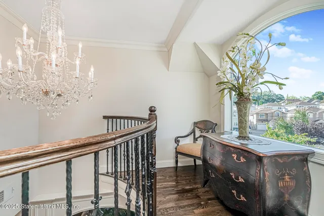 a bedroom with a bed a flat screen tv and a chandelier
