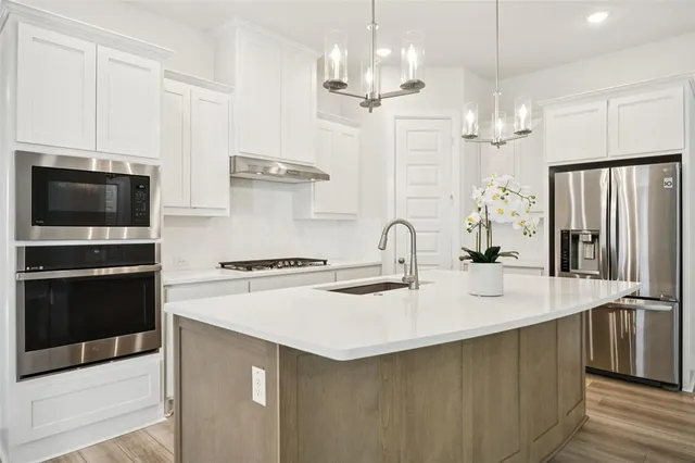 a kitchen with stainless steel appliances a sink stove and refrigerator