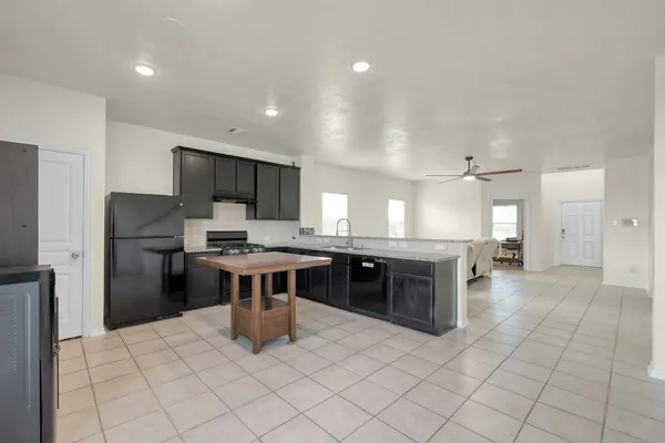 a open kitchen with stainless steel appliances granite countertop a refrigerator and a sink