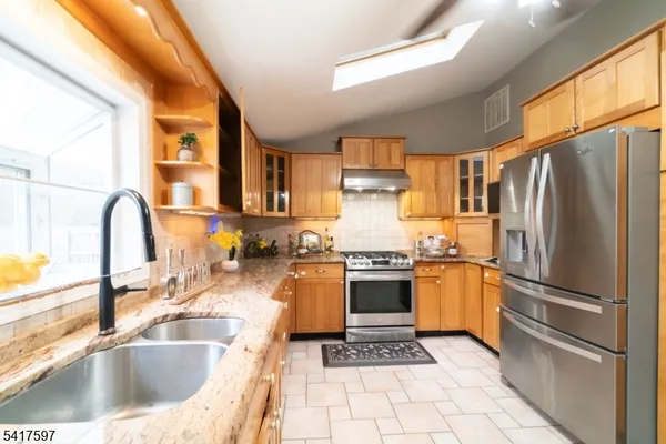 a kitchen with granite countertop a sink appliances and cabinets
