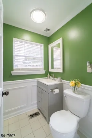 a bathroom with a sink a toilet a mirror a bathtub and next to a window