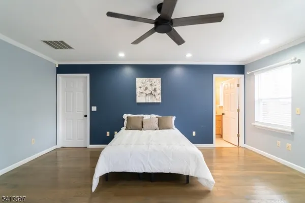 a bedroom with a large bed and a chandelier