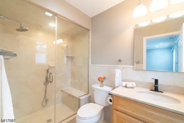 a bathroom with a granite countertop sink toilet a shower and a mirror