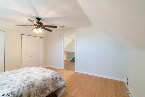 a bedroom with a bed and a chandelier fan