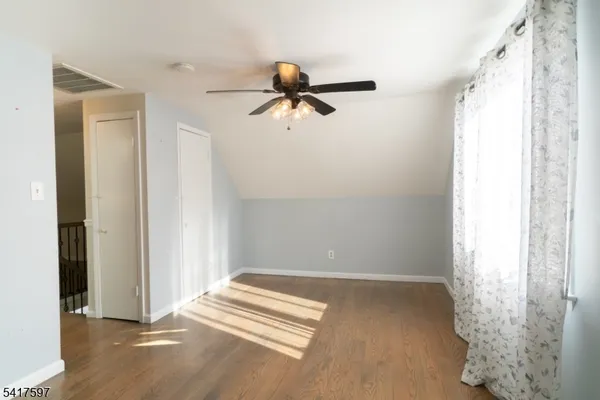 a view of a livingroom with a chandelier fan and wooden floor