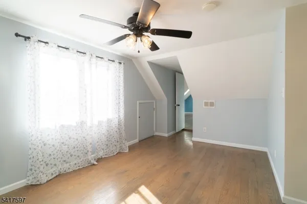 a view of a big room with wooden floor and windows in a room