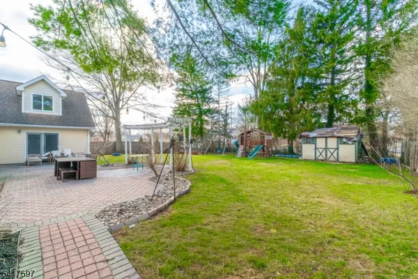 a view of a house with backyard and a tree