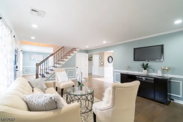 a living room with furniture kitchen view and a flat screen tv