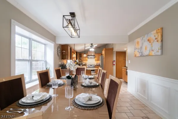 a very nice looking dining room with furniture a chandelier and wooden floor