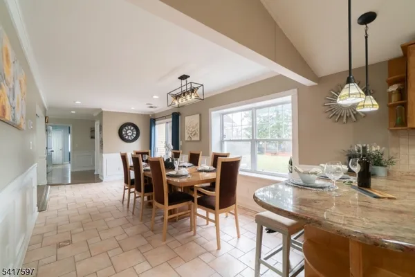 a dining room with furniture a chandelier and window