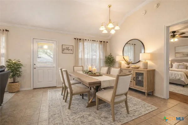 a view of a dining room with furniture and chandelier