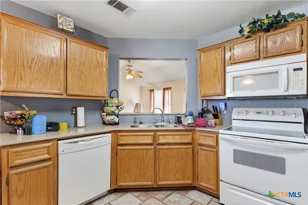 a kitchen with cabinets appliances and a window