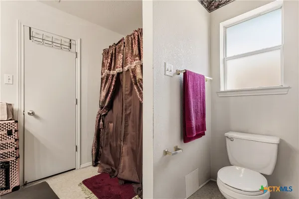 a bathroom with a toilet and a shower