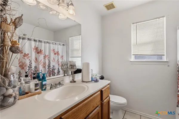 a bathroom with a sink vanity mirror and toilet