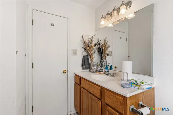 a bathroom with a sink vanity and a mirror