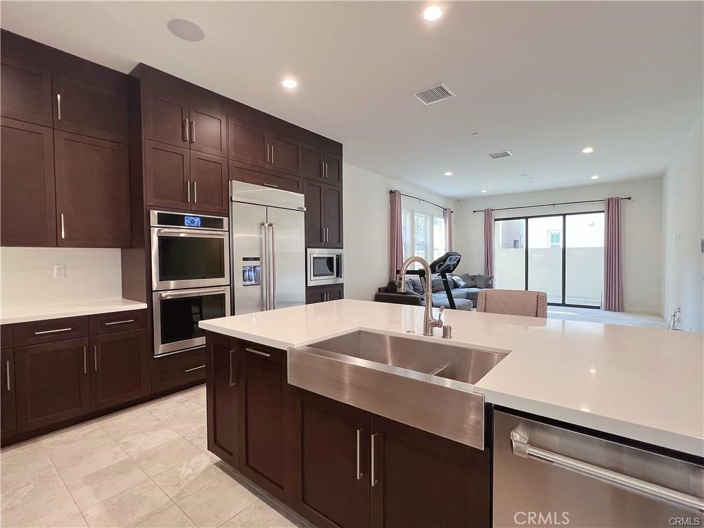 185 Bryce Run Lake Forest, CA 92630 - Photo 9 of 34 a kitchen with kitchen island a sink table and chairs