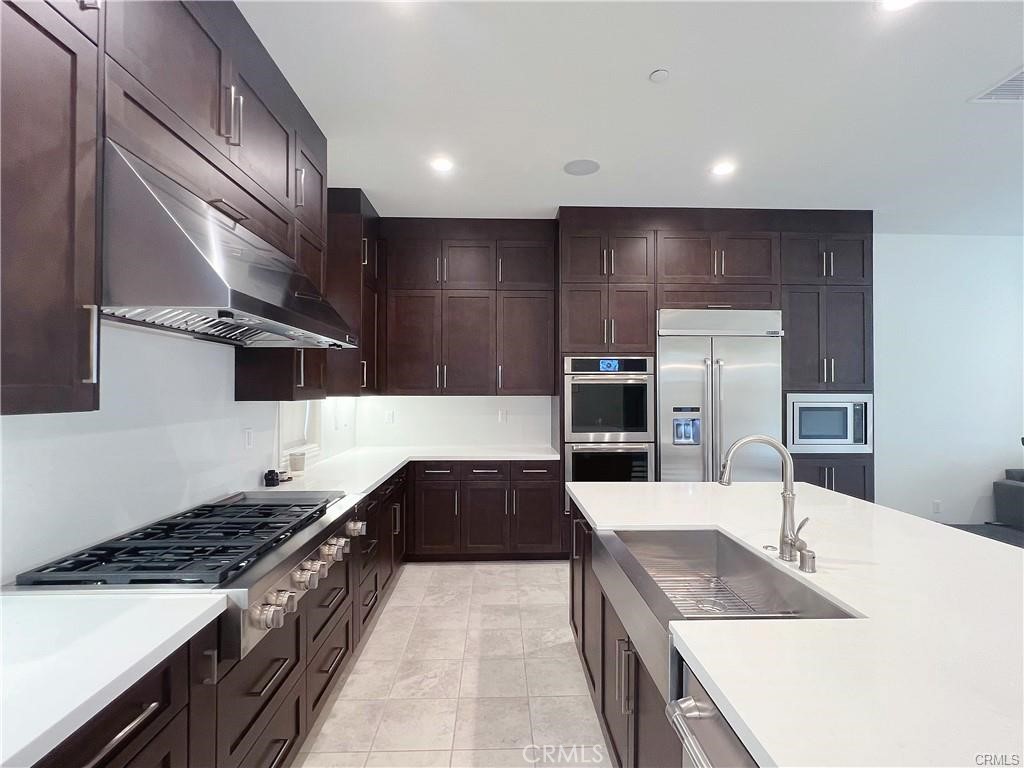 185 Bryce Run Lake Forest, CA 92630 - Photo 10 of 34 a large kitchen with stainless steel appliances a sink a stove a refrigerator and a cabinets