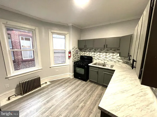 a kitchen with a stove a refrigerator and a wooden floor