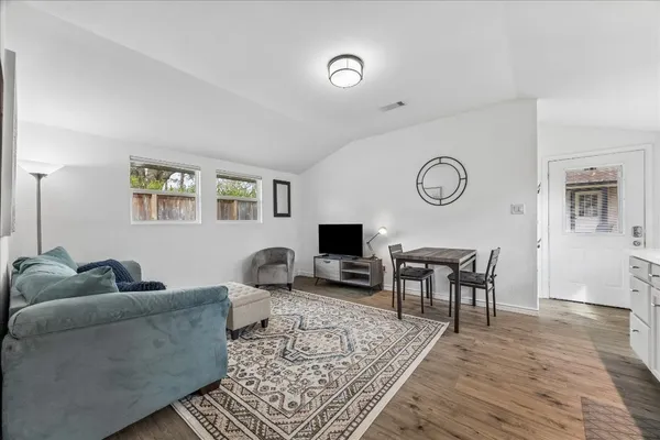 a living room with furniture and view of kitchen