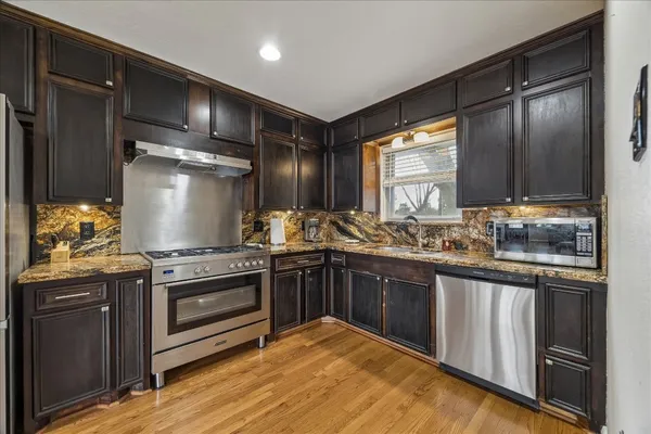 a kitchen with stainless steel appliances granite countertop a stove and a refrigerator