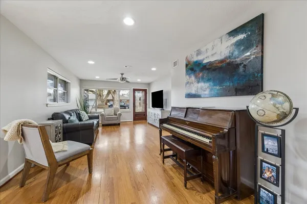 a living room with furniture a wooden floor and a bookshelf