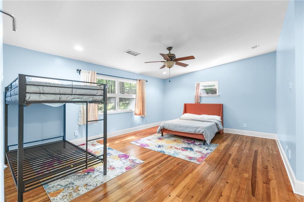 6567 Tahiti Way Flowery Branch, GA 30542 - Photo 15 of 36 a bedroom with a bed and wooden floor