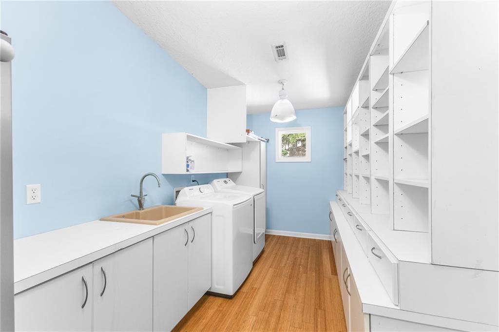6567 Tahiti Way Flowery Branch, GA 30542 - Photo 16 of 36 a spacious bathroom with a sink and a mirror