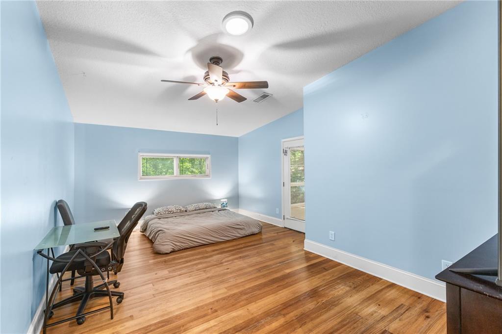 6567 Tahiti Way Flowery Branch, GA 30542 - Photo 17 of 36 a bedroom with a bed and a chandelier