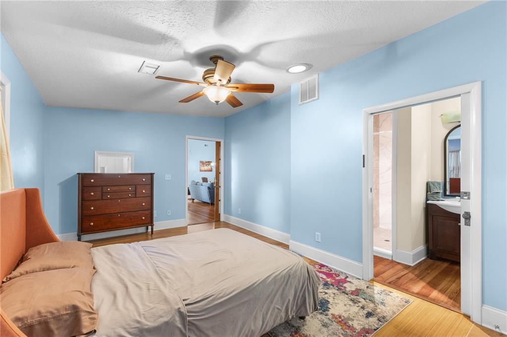 6567 Tahiti Way Flowery Branch, GA 30542 - Photo 19 of 36 a bedroom with a bed and a chandelier