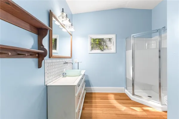 a bathroom with a sink a mirror and a shower