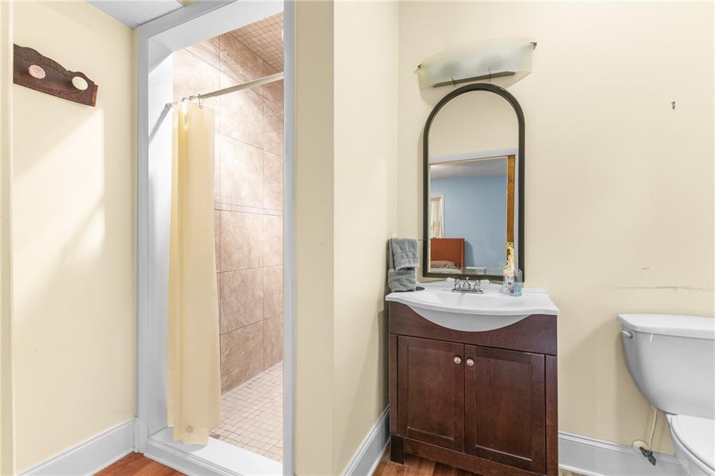 6567 Tahiti Way Flowery Branch, GA 30542 - Photo 24 of 36 a bathroom with a sink a toilet and a mirror
