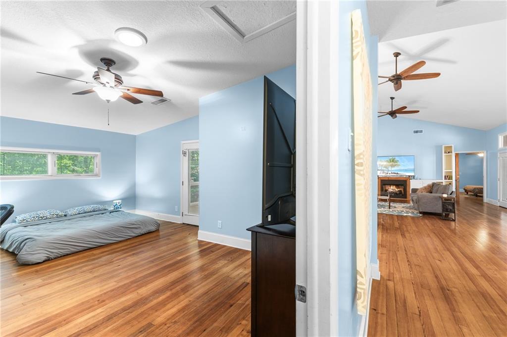 6567 Tahiti Way Flowery Branch, GA 30542 - Photo 28 of 36 a bedroom with a bed and wooden floor