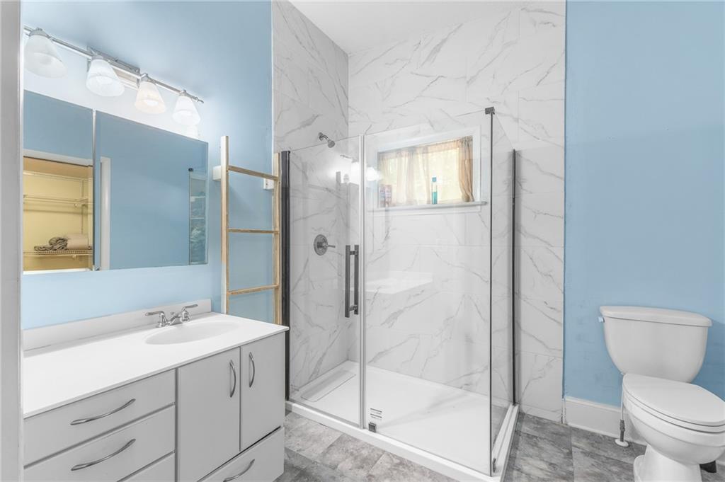 6567 Tahiti Way Flowery Branch, GA 30542 - Photo 29 of 36 a bathroom with a shower sink mirror and toilet