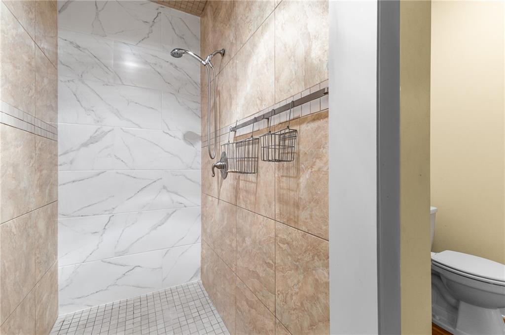 6567 Tahiti Way Flowery Branch, GA 30542 - Photo 30 of 36 a bathroom with a shower and a toilet