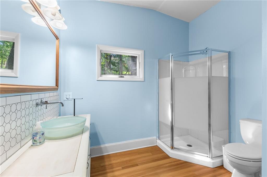 6567 Tahiti Way Flowery Branch, GA 30542 - Photo 32 of 36 a bathroom with a granite countertop shower and a toilet