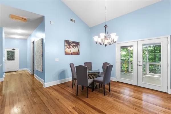 a dining room with furniture a large window and wooden floor