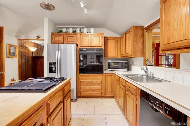 a kitchen with stainless steel appliances granite countertop a sink and a refrigerator