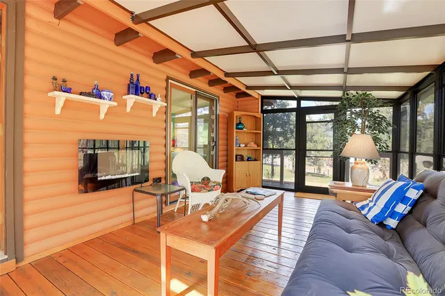 a living room with furniture a flat screen tv and a floor to ceiling window