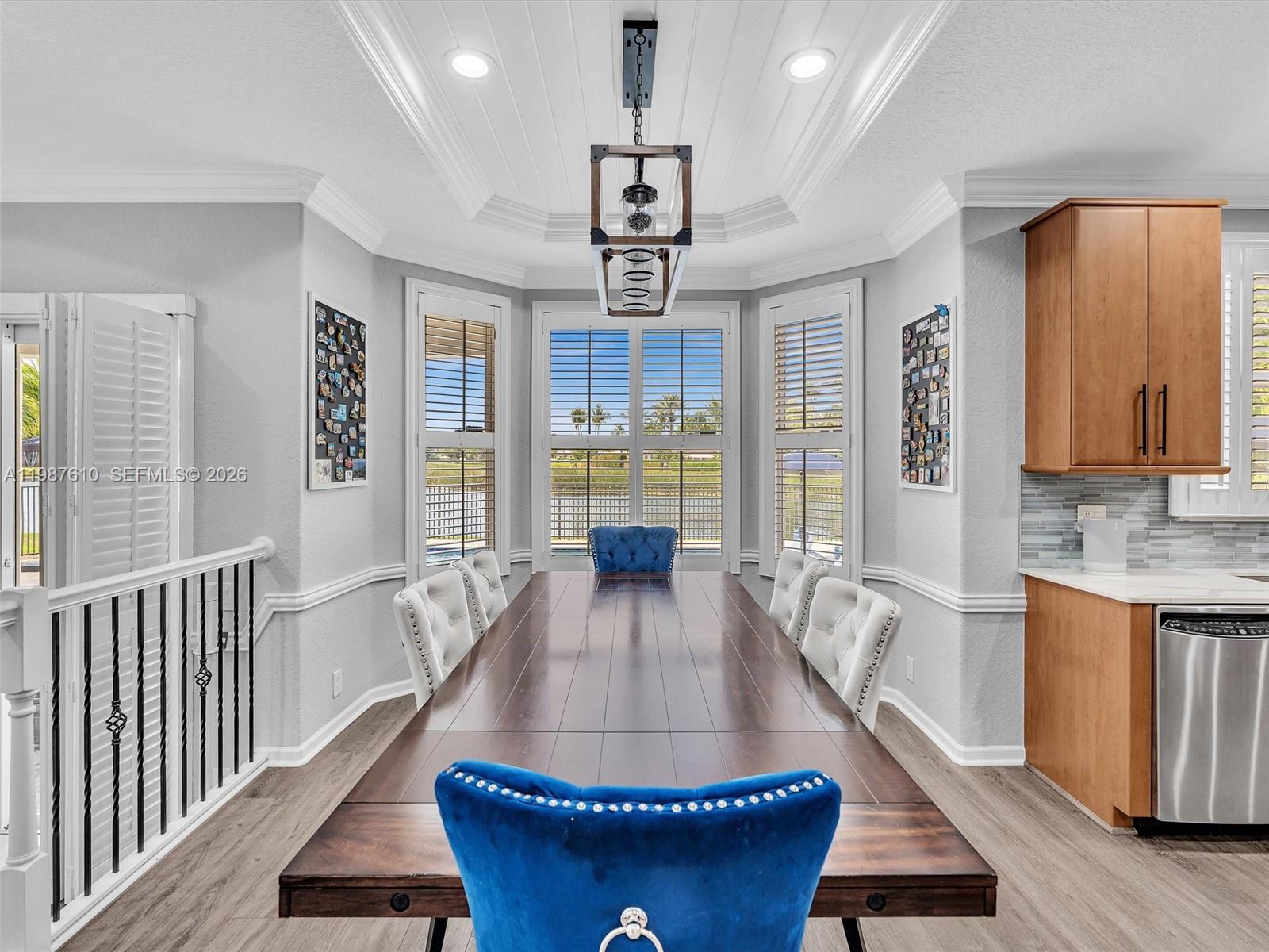 8878 Cobblestone Point Circle Boynton Beach, FL 33472 - Photo 20 of 89 a dining room with wooden floor a chandelier a wooden table and chairs